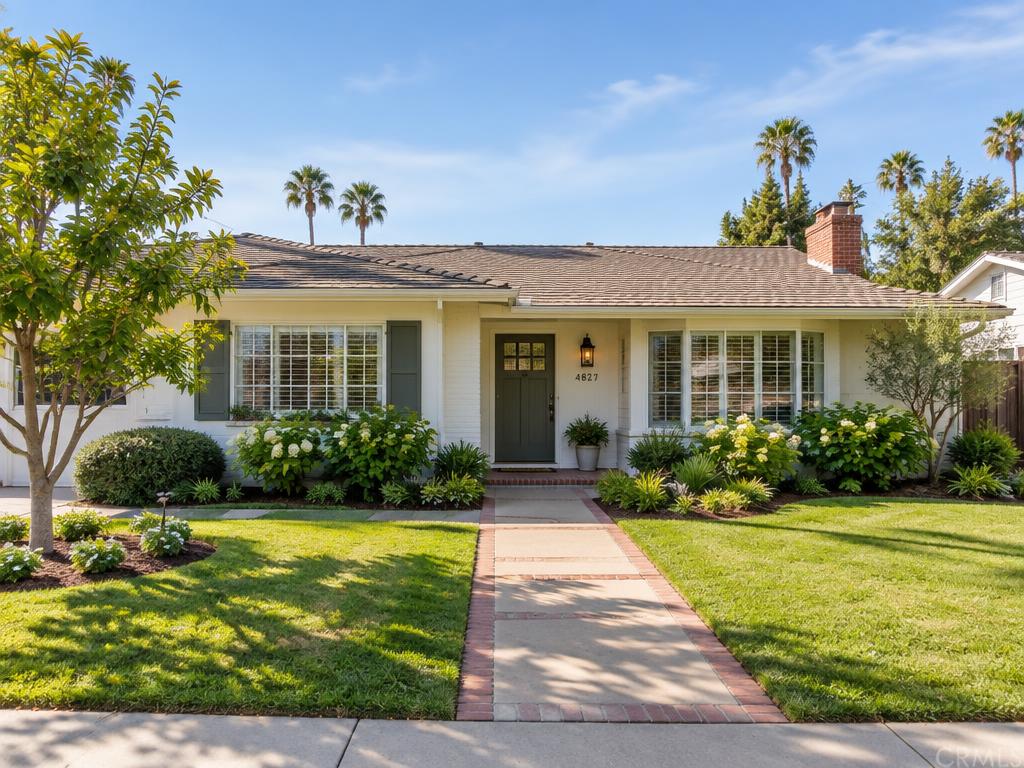 The front of a single-story home with a tidy lawn and wide walkway